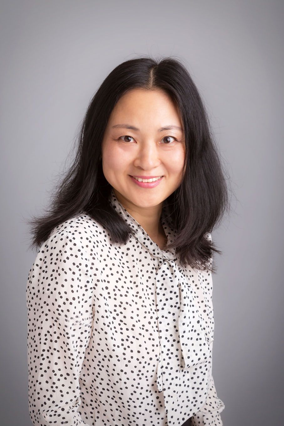 A portrait of woman man taken in a studio set up with backdrop and lighting equipment